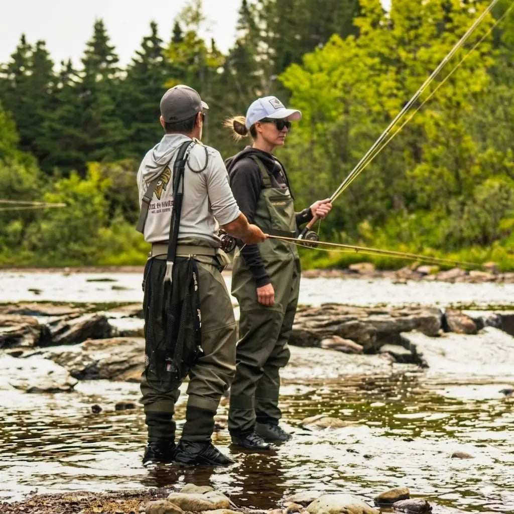Pêchecheuse à la mouche en waders dans une rivière