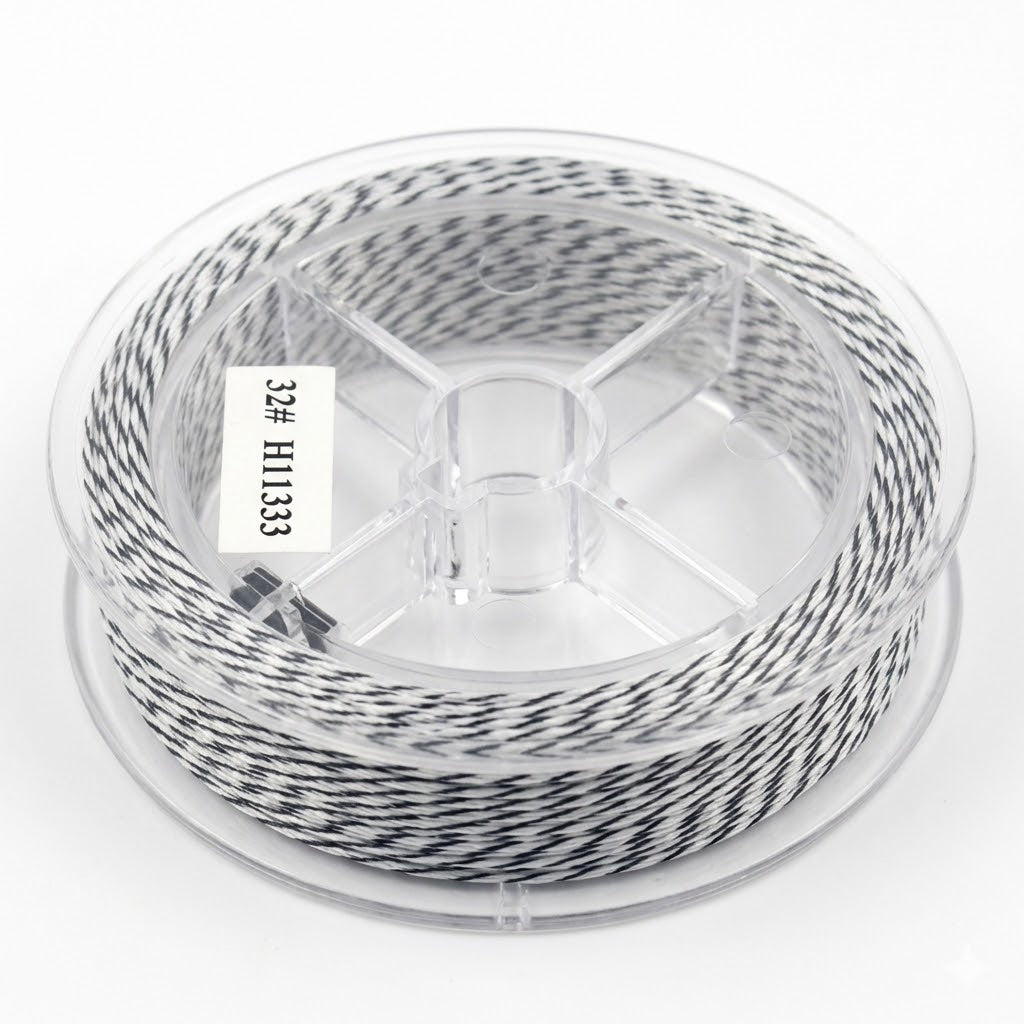 Une image de studio nette d'une bobine de fil de pêche tressé au motif camouflage noir blanc, enroulée sur un dévidoir en plastique transparent, sur un fond blanc.
