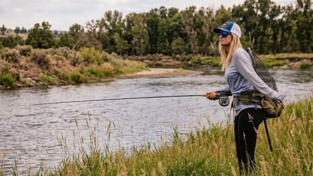 Pêchecheuse à la mouche en waders dans une rivière