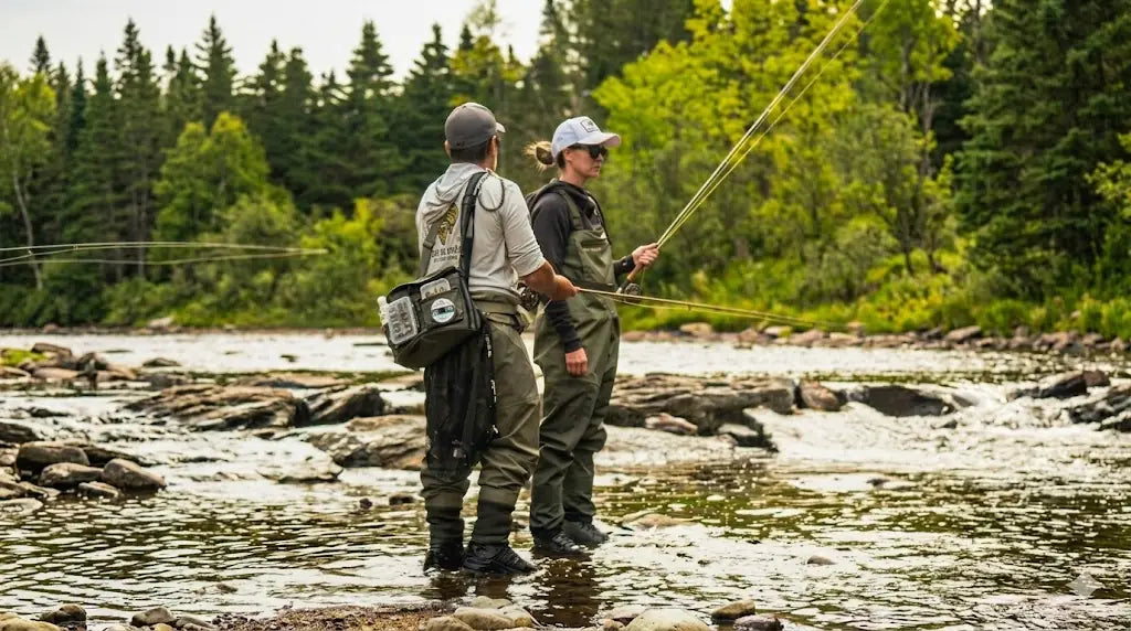 Instructeur certifié de pêche à la mouche enseignant les techniques de lancer sur une rivière du Québec